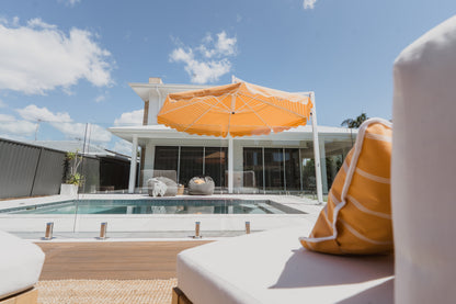 Orange and white striped pool side umbrella